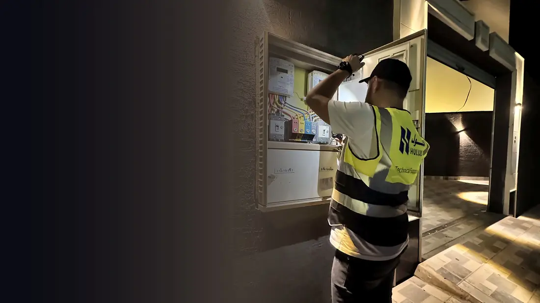 لوحة عدادات وقواطع كهربائية يفحصها فني من حلول